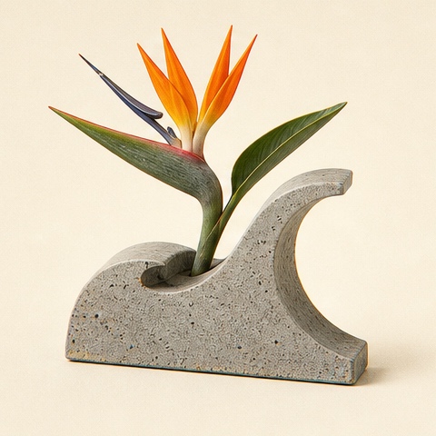 A bird-of-paradise blooming through a cast-concrete wave.