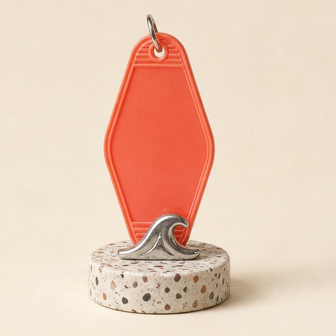 A blank coral motel tag carrying one small chrome wave.